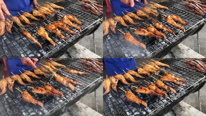 用竹子塞住的草药烧烤鸡翅，炉子上的鸡肉烤架，泰国的街头食品。