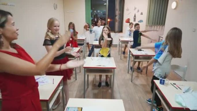 一群小学生在课堂上与女老师一起唱歌跳舞