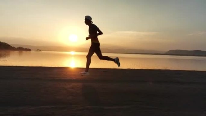 男子在日落时奔跑海边奔跑狂奔