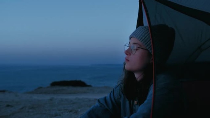 年轻女子的肖像在营地旅行中观看日落