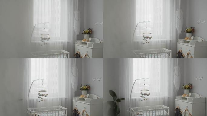 时尚明亮的现代婴儿房内部: 婴儿床、悬挂式手机、更衣桌