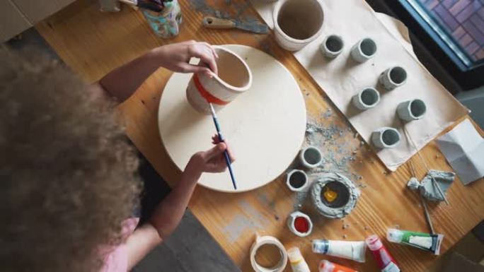 一位艺术家在她的陶器工作室画混凝土花盆