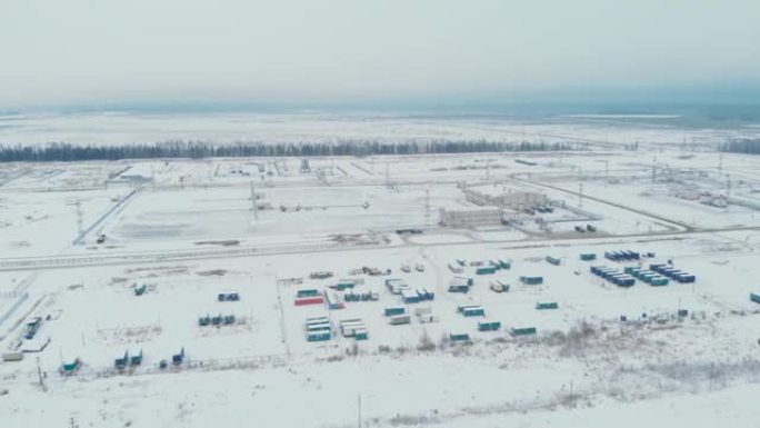 电影空中无人机镜头。油气田基地和流动职工之家。冬季的西伯利亚针叶林。直升机飞行