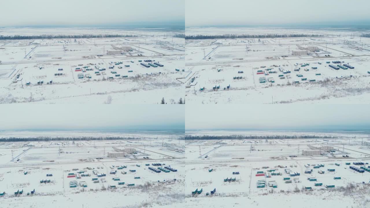 电影空中无人机镜头。油气田基地和流动职工之家。冬季的西伯利亚针叶林。直升机飞行