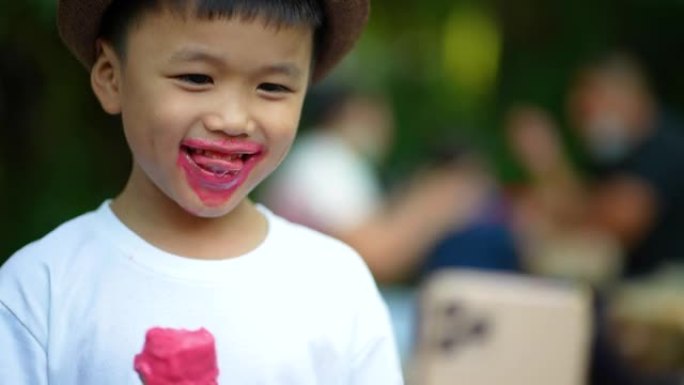 亚洲男孩舔融化的冰淇淋和微笑。幸福与夏天的概念