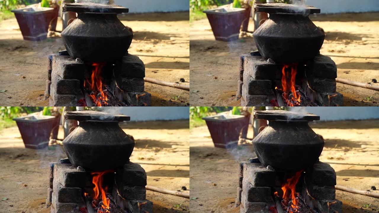 在农村炉灶上的一所乡村房屋中的旧印度厨房中明火上制作食物的传统方法。带红色照明火的砖炉视图。