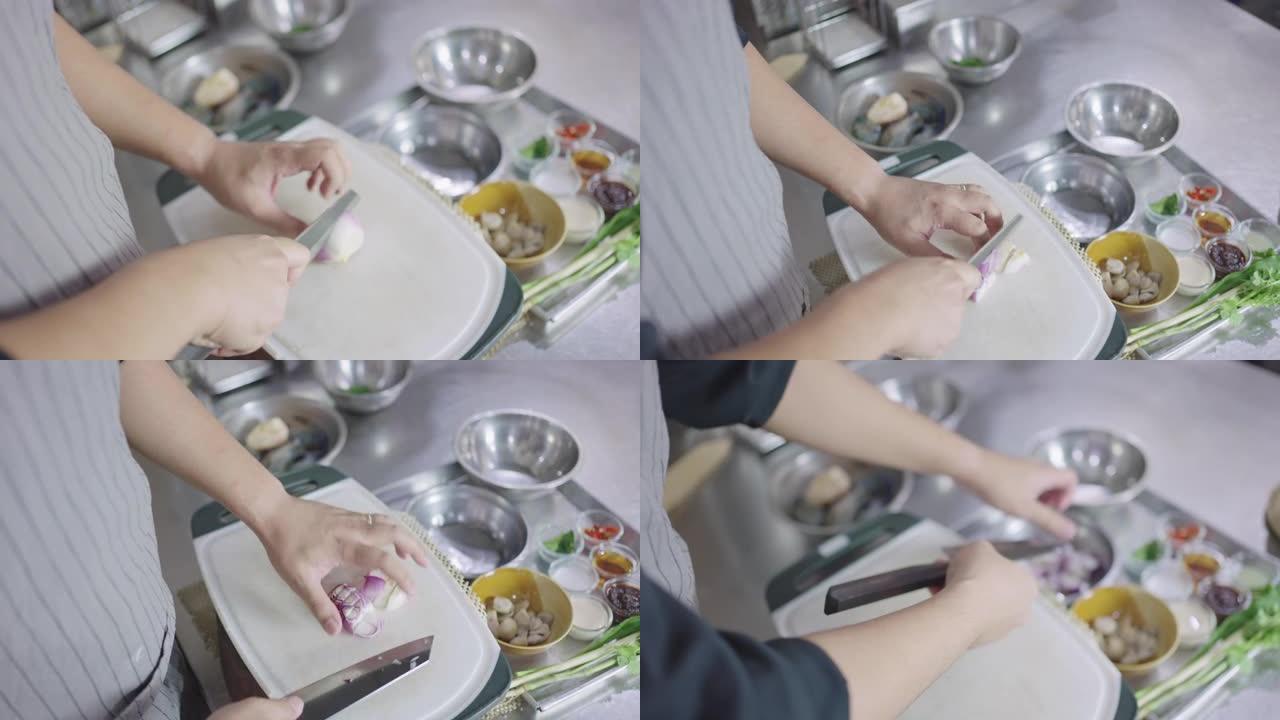 SLO MO: 厨师用菜刀将葱切碎并放入碗中。