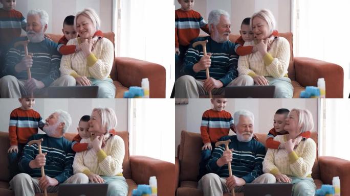 爷爷和奶奶在客厅的沙发上与孙子孙女交谈，与祖父母一起享受并玩乐。老人招待双胞胎