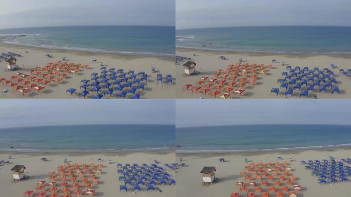 鸟瞰图，在蓝色和红色的两组海滩帐篷周围盘旋