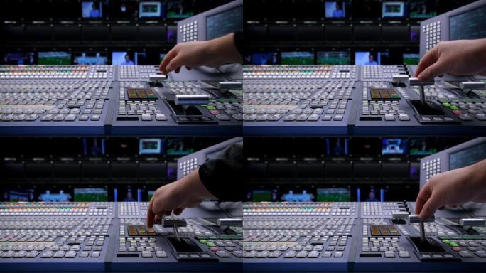 视觉切换器工作室导演广播视频混合器操作-手的特写。在视觉混合器上工作的摄影师的手，切换电视面板。