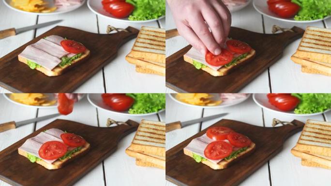 用沙拉，番茄，火腿和奶酪制作三明治的过程。美国美食。快餐。烹饪。
