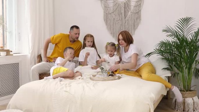 六口之家幸福的大家庭躺在家里的床上玩得开心。