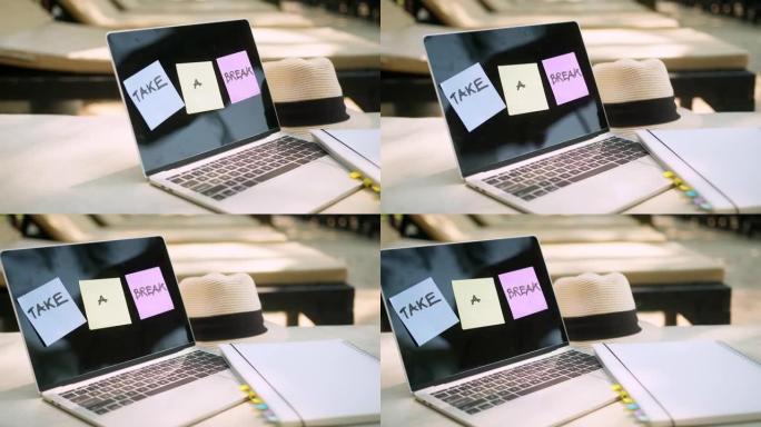 从工作理念中休息一下，用纸便签和文字休息一下，在笔记本电脑屏幕上画画放在放松的木凳上，旁边是游泳池假
