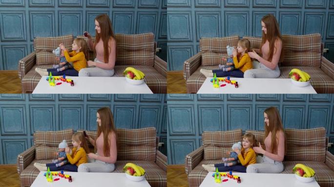 妈妈照顾，在客厅里给女儿的女孩梳头，玩玩具娃娃的孩子