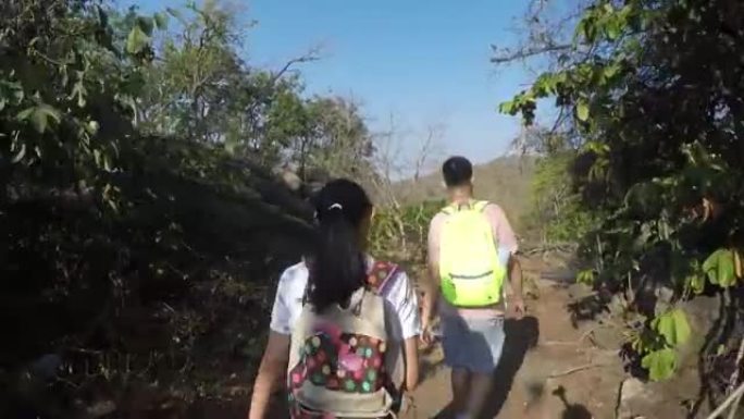 快乐的亚洲背包客儿童与阳光明媚的日子一起在山上行走，生活方式理念。