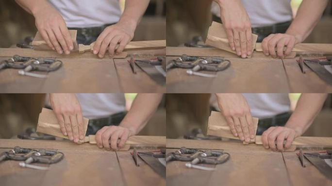 木匠在木工商店的木板上使用砂纸的特写镜头