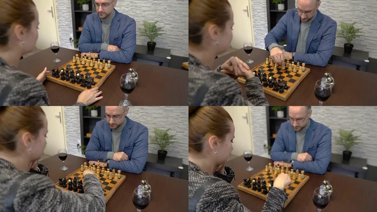 年轻夫妇坐在家里的桌子上下棋