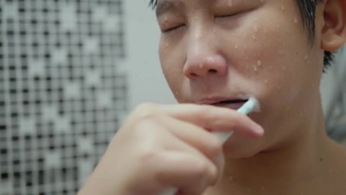 快乐的亚洲青春期男孩在家浴室刷牙，日常生活方式理念。