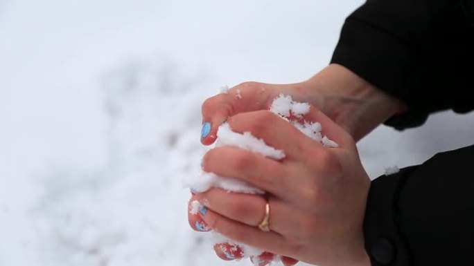 女性的手在白雪皑皑的花园里雕刻雪球