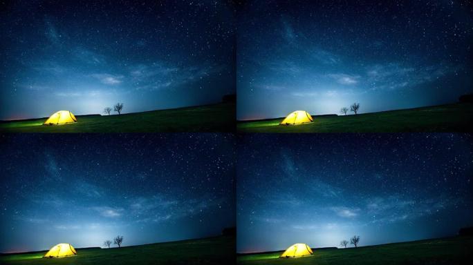 闪烁的星空下的夜山中发光的露营帐篷。电影。
