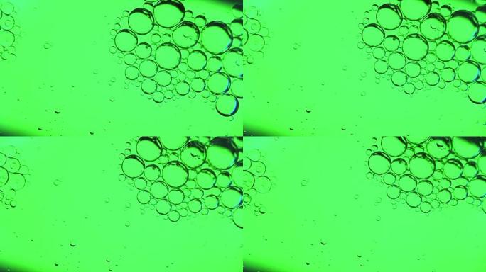 运动中的水面上的油泡，浅绿色背景上的油泡，宏观，闪屏，模板，复制空间