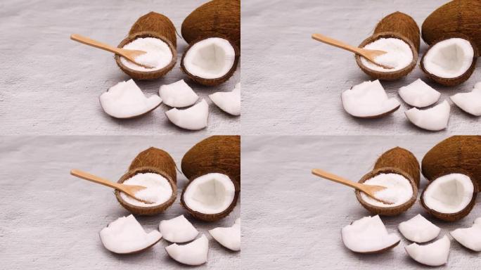 椰子粉和木勺中的椰子壳和切成薄片的椰子。停止运动