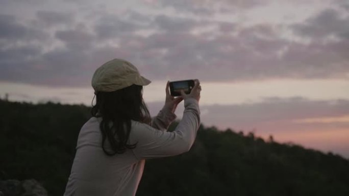 女人在大自然中用手机拍照。