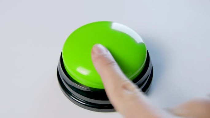 年轻女子用手指和手掌按下绿色按钮。按下圆形光泽按钮，俯视图。激活，发射一些东西。打开和关闭。
