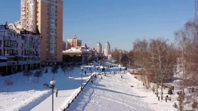鸟瞰图。在冬天阳光明媚的寒冷日子里，人们在白雪覆盖的城市公园里散步和呼吸新鲜空气。自然和新鲜空气