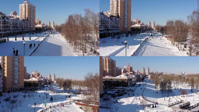 鸟瞰图。在冬天阳光明媚的寒冷日子里，人们在白雪覆盖的城市公园里散步和呼吸新鲜空气。自然和新鲜空气