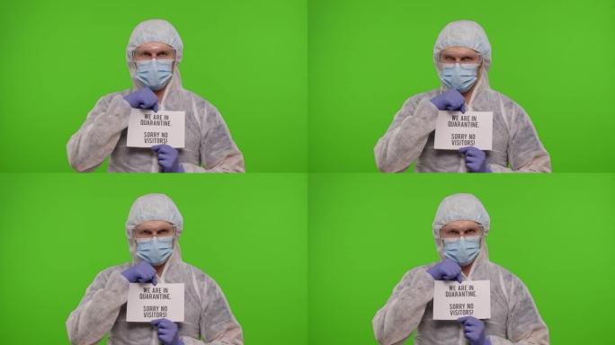 穿着PPE西装的医生，纸上有文字-我们在检疫，对不起，没有访客，冠状病毒
