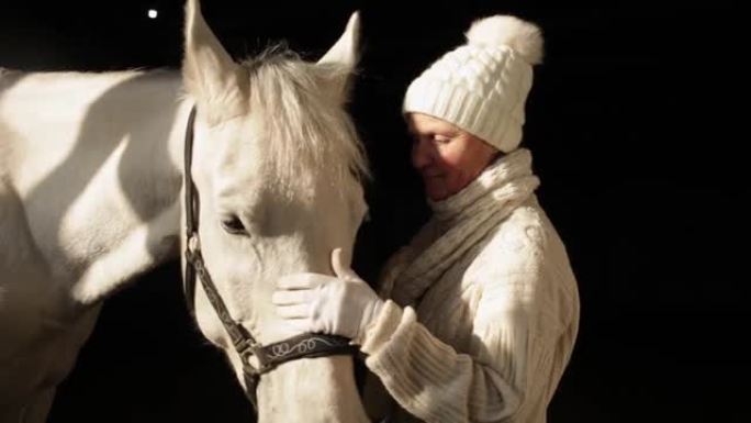 一位老年妇女喜欢她的马。亲吻、交谈、抚摸、拥抱。美丽的动物，照顾宠物