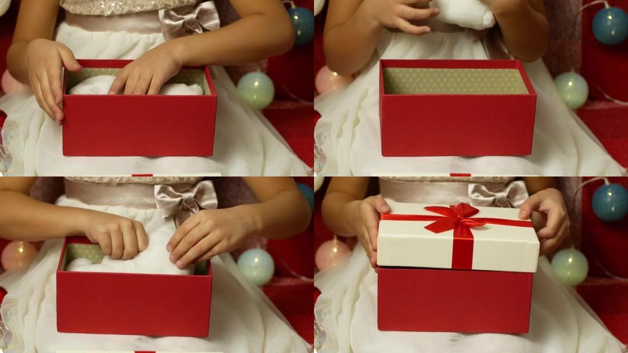 一个穿着漂亮衣服的小女孩打开了圣诞节和新年的生日礼物，并拿出了一个惊喜明亮的圣诞树装饰品。孩子为圣诞