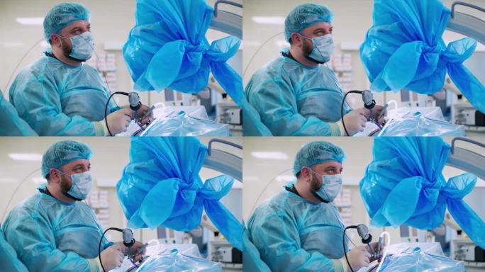 专业医生进行肾脏手术。蓝色医用口罩和制服的外科医生使用现代医疗器械粉碎肾脏结石。
