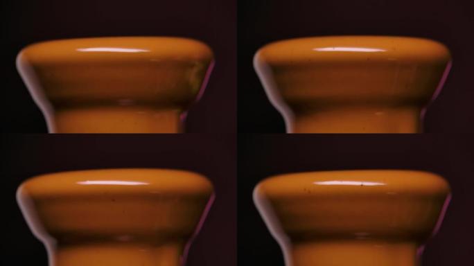 与液态融化的巧克力在黑色背景上隔离的级联。热牛奶巧克力以慢动作从喷泉中流下。关闭模糊形式的甜棕色巧克