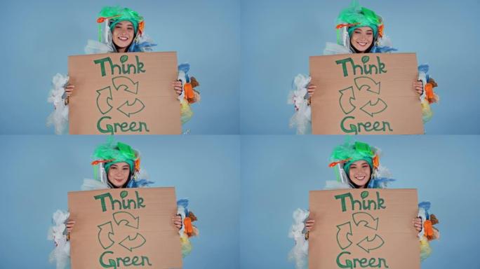 穿着垃圾西装的女人拿着海报，上面写着绿色。