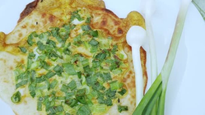 白盘上的洋葱披萨。乌德穆尔特的民族美食: 塔巴尼。洋葱羽毛和玉米粉圆饼