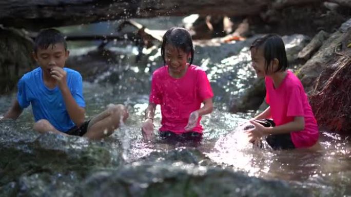 孩子们在旅游暑假山上的瀑布里玩耍，亚洲快乐的孩子们在大自然中旅行
