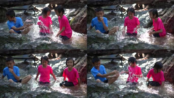 孩子们在旅游暑假山上的瀑布里玩耍，亚洲快乐的孩子们在大自然中旅行