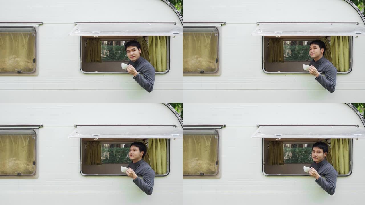 快乐的年轻人在露营车房车的窗户上喝咖啡