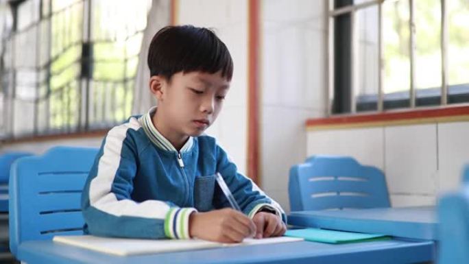 亚洲小学生在课堂上做作业时思考