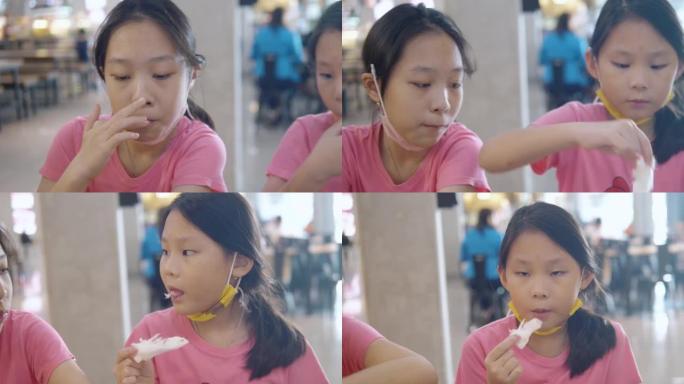 快乐的亚洲儿童交谈，享受棉花糖和一些小吃，一起在美食广场与家庭，生活方式的概念。