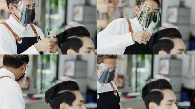 亚洲男子在理发店理发，美发师戴着医用口罩保护自己免受病毒。理发师在他的商店理发