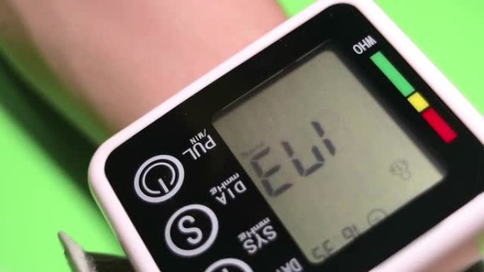 一个人通过自动数字眼压计测量血压。特写。绿色背景上的视频。全高清。