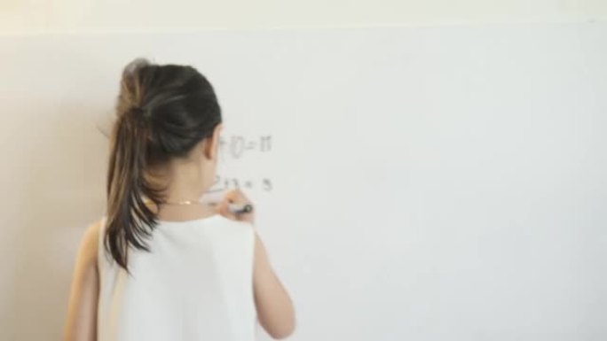 快乐的亚洲女孩在家上学期间在白板上写数学科目的问题和答案，呆在家里的概念。
