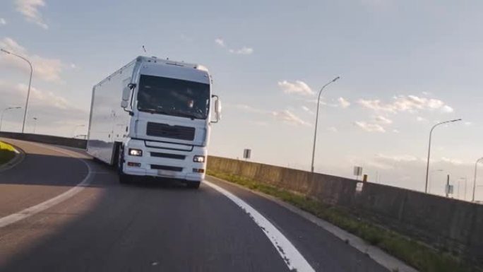 载货卡车，载货拖车在高速公路上行驶。白色卡车凌晨送货