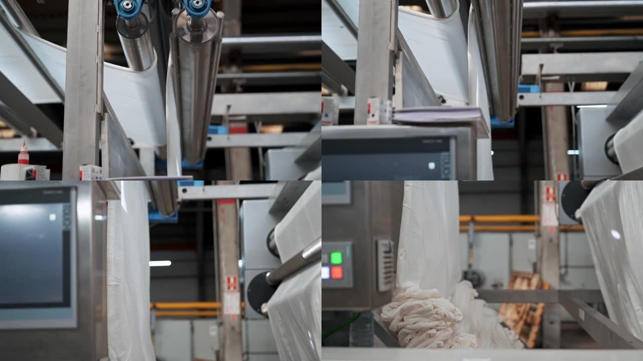 带钢桶的工业机器正在折叠白色机织物，在slowmo的工厂自动弄乱衣服