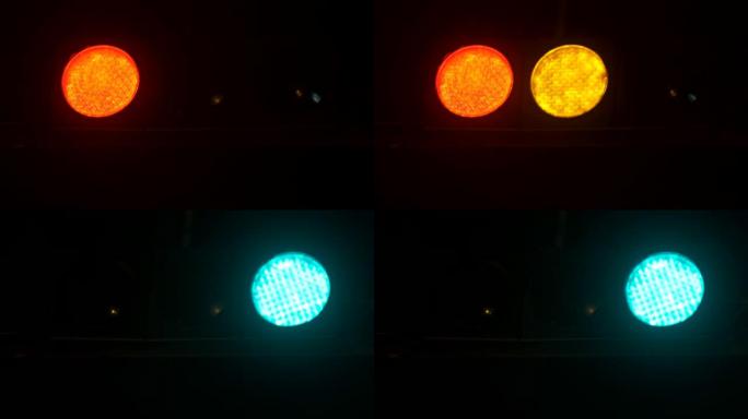交通信号灯在晚上从红色切换到绿色。垂直悬挂交通灯