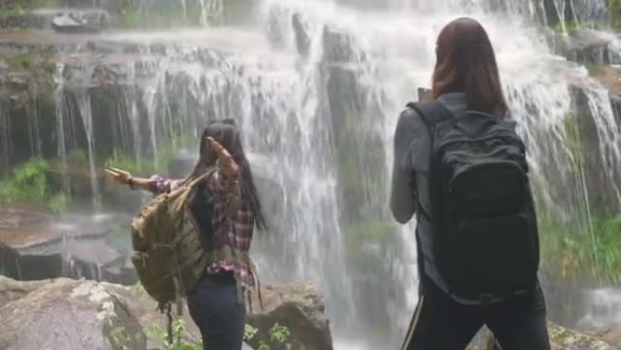 女人在热带新鲜瀑布下尽情享受大自然