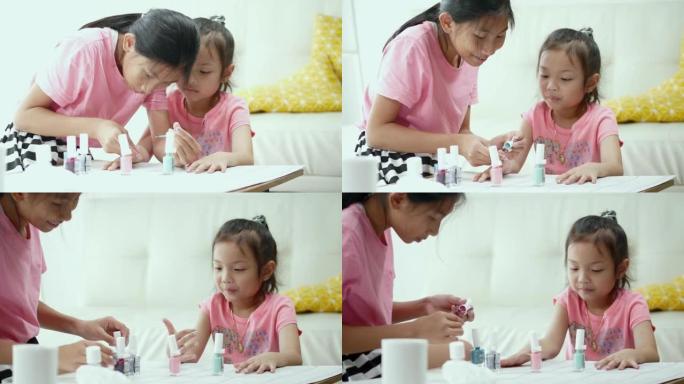 快乐的亚洲儿童画指甲油，同时在家里一起放松，生活方式的概念。